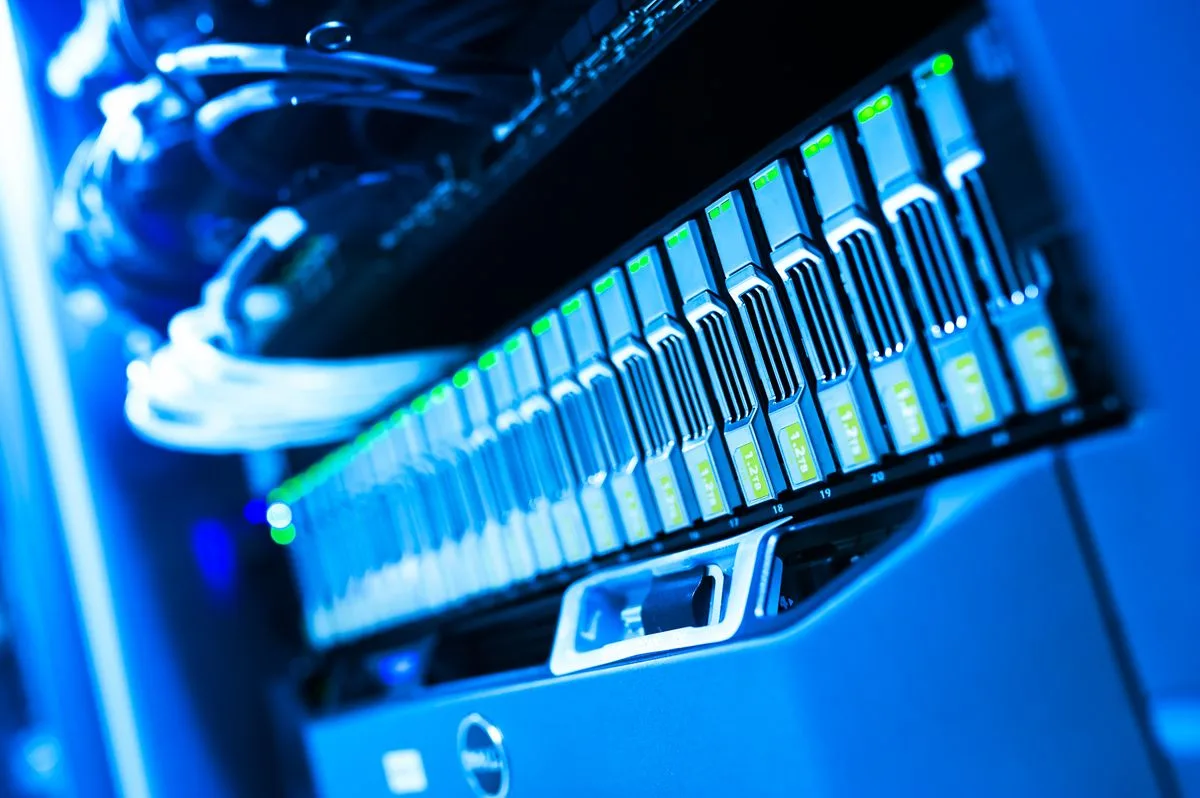 Close-up of a blue-lit server rack in a data center, representing the infrastructure layer that governs and controls AI workloads